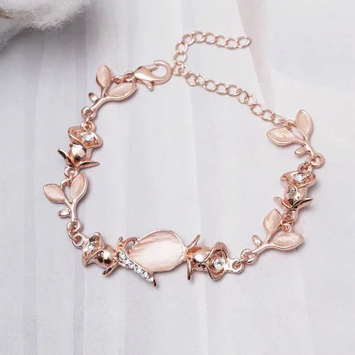 Rose gold bracelet with floral designs on a white fabric background