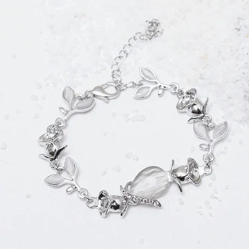 Silver bracelet with leaf and shell designs on a white background