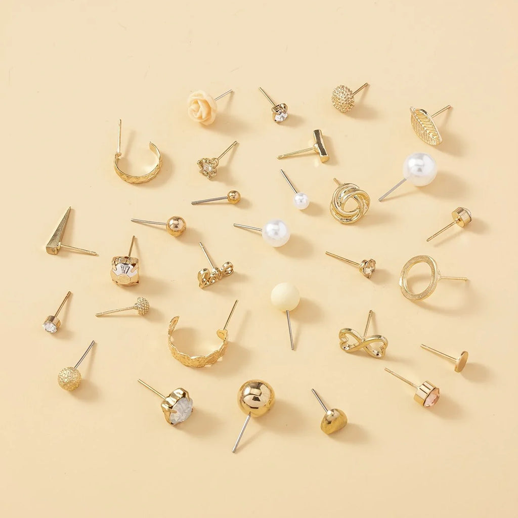 Various gold earrings on a beige background
