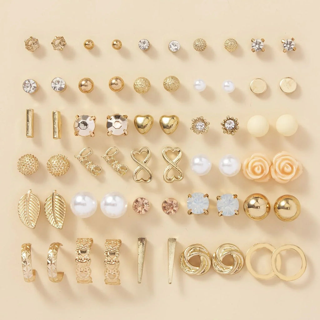 Collection of various gold and rose gold earrings on a beige background