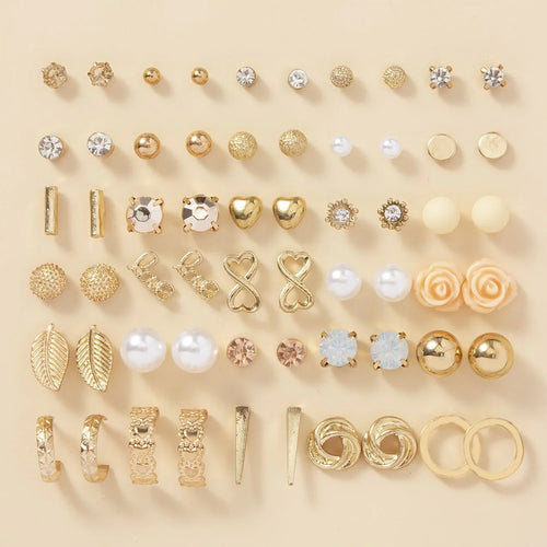 Collection of various gold and rose gold earrings on a beige background