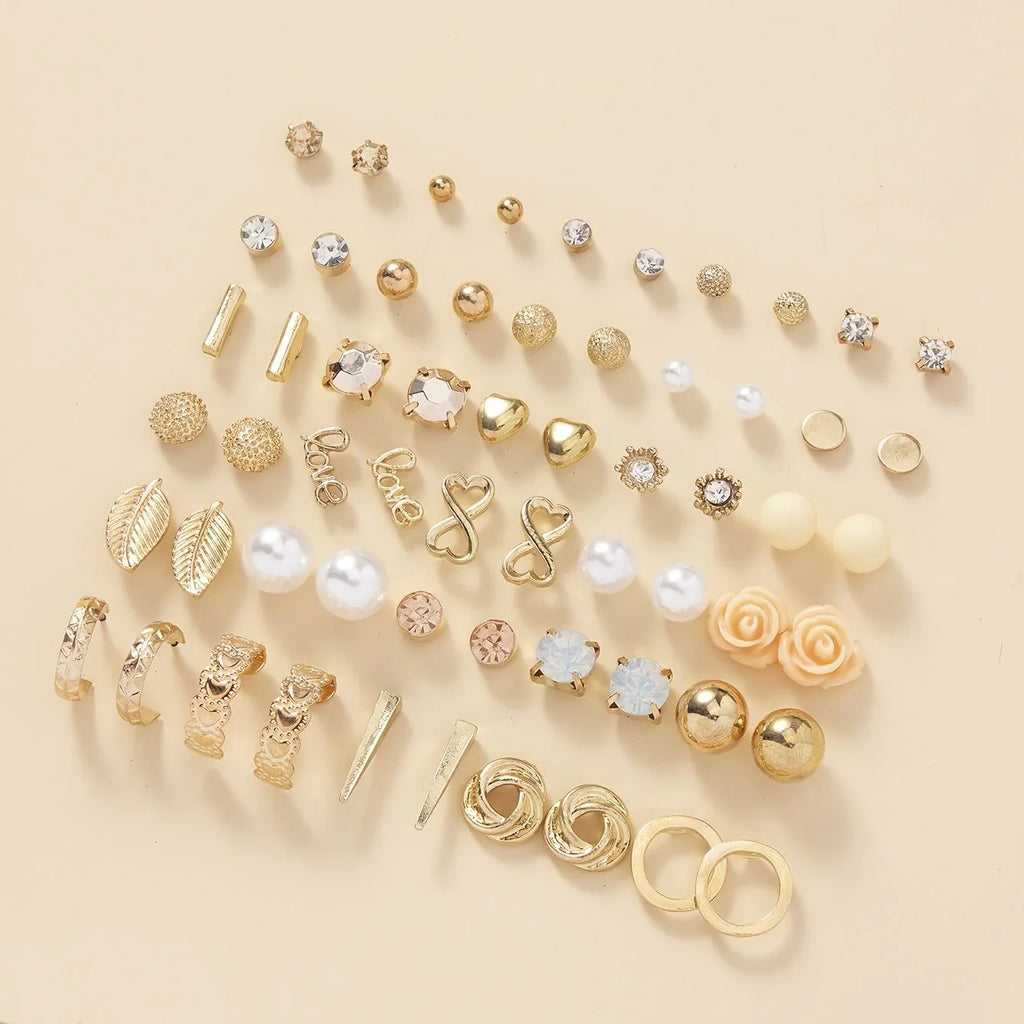 Assorted gold and pearl earrings on a beige background