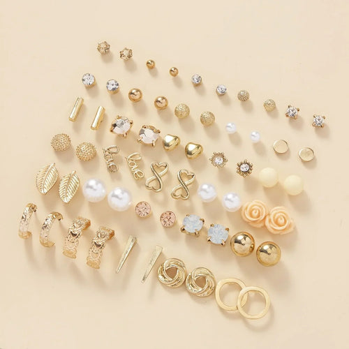 Assorted gold and pearl earrings on a beige background